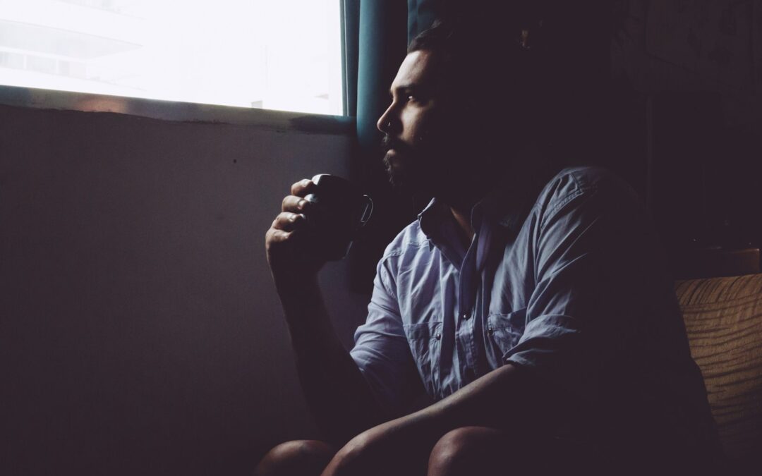 man sitting on chair holding mug